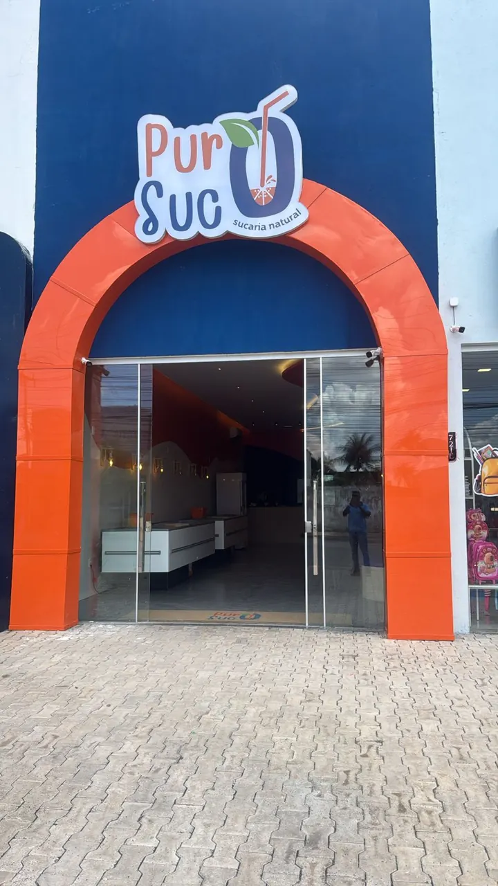 Fachada atual da Puro Suco LEM com arco laranja e identificação da unidade